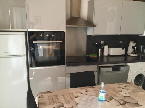 a kitchen with a table with a bottle of water on it at Mazet Lavande in Saint-Martin-de-Brômes