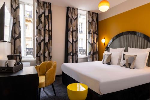 パリにあるオテル レジーナ オペラ グラン ブールヴァールの大きなベッドと椅子が備わるホテルルームです。