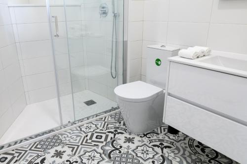 e bagno con doccia, servizi igienici e lavandino. di Lovely Home a Lisbona