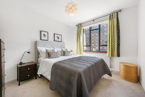 a bedroom with a large bed and a window at Veeve - Thirties Icon By Sadler's Wells in London