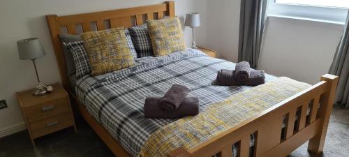 une chambre avec un lit avec des serviettes dessus dans l'établissement Espedair Apartment, à Paisley