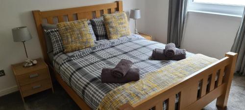 a bedroom with a bed with towels on it at Espedair Apartment in Paisley