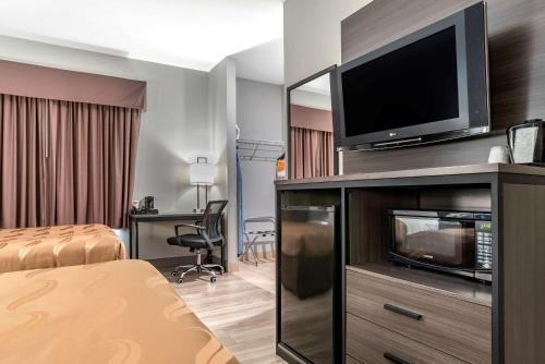 a hotel room with a flat screen tv on a entertainment center at Quality Inn & Suites Demopolis in Demopolis
