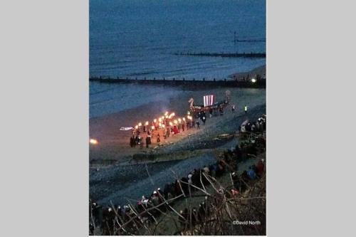 a group of people walking on the beach at night at Leylands - Perfect location near town and beach in Cromer