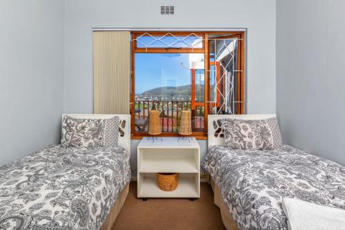 a bedroom with two beds and a window at Prospect Cottage in Knysna