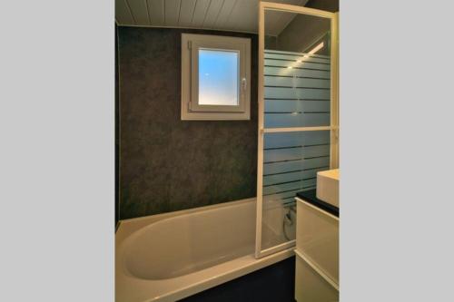 uma casa de banho com uma banheira e uma janela em Maison de vacances dans résidence avec piscine em Sarzeau