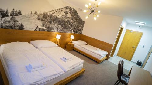 - une chambre avec 2 lits et une photo de montagne dans l'établissement Apartmány 45 Valča, à Valča