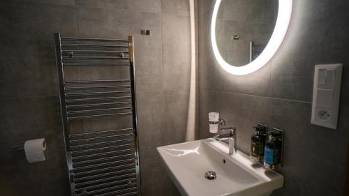 y baño con lavabo y espejo. en Apartmány 45 Valča, en Valča