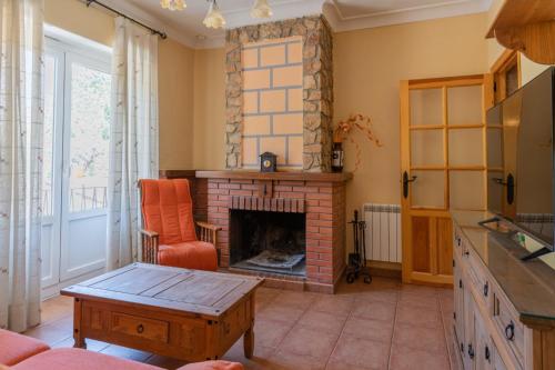 a living room with a fireplace and a chair at Casas Rurales Balcón de las Mayas in Ayna