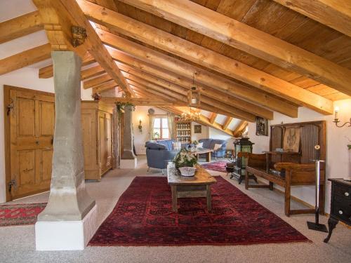 a living room with a wooden ceiling with beams at Ferienwohnungen Blos in Grassau