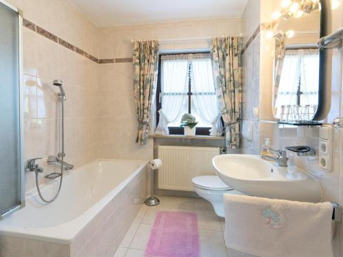 a bathroom with a tub and a sink and a toilet at Ferienwohnungen Blos in Grassau