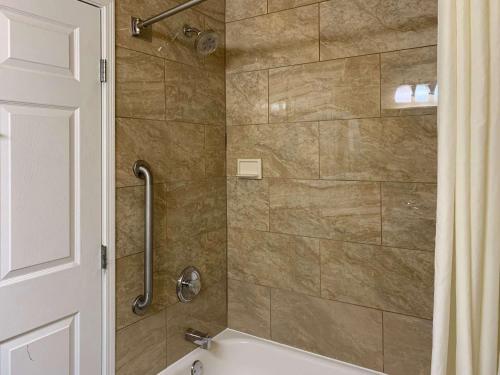 a bathroom with a shower with a tub at Comfort Inn Saint Paul East in Oakdale