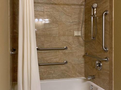 a shower with a tub and a shower curtain at Comfort Inn Saint Paul East in Oakdale