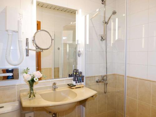 ein Bad mit einem Waschbecken und einer Dusche in der Unterkunft Novotel Moscow Centre in Moskau