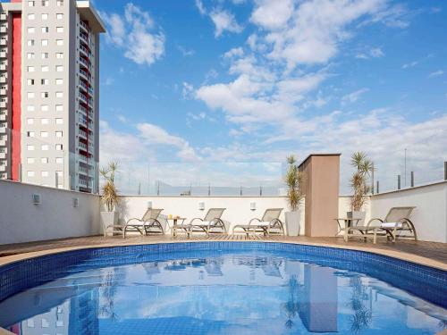 a swimming pool on the roof of a building at ibis Styles Piracicaba in Piracicaba