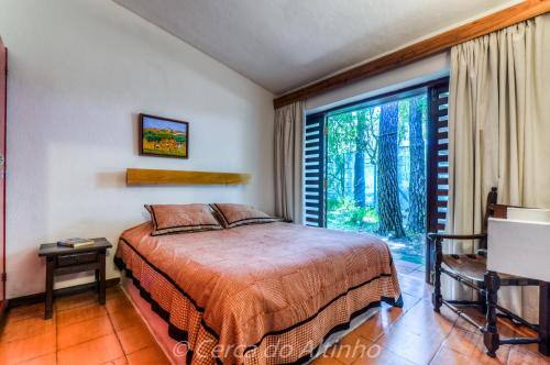 a bedroom with a bed and a large window at Cerca do Altinho in Vila Nova de Milfontes