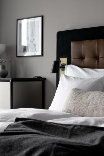 a bedroom with a black and white bed and a picture at Clarion Hotel Sundsvall in Sundsvall