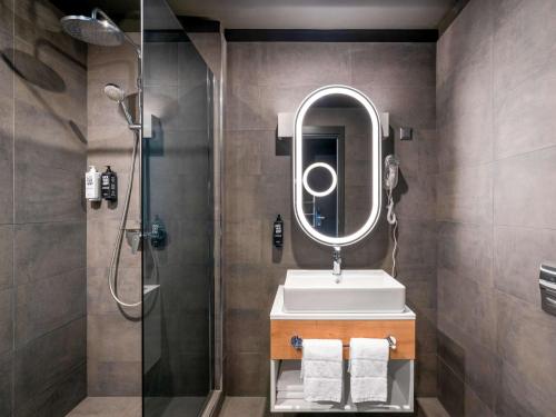 a bathroom with a shower and a sink and a mirror at ibis Bucharest Politehnica in Bucharest
