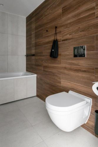 a bathroom with a white toilet and a bath tub at Clarion Hotel Sundsvall in Sundsvall