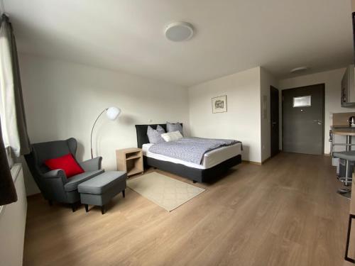 1 dormitorio con 1 cama y 1 silla en Gästehaus Vondey, en Salzkotten
