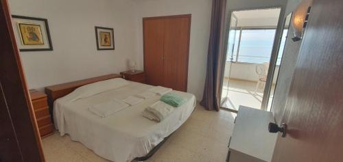 a bedroom with a bed with towels on it at COBLANCA 20 - Fincas Arena in Benidorm