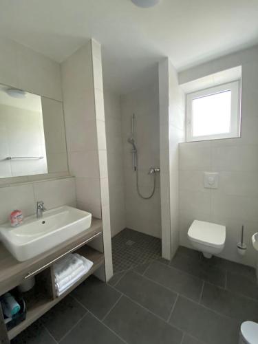 a white bathroom with a sink and a toilet at Gästehaus Vondey in Salzkotten