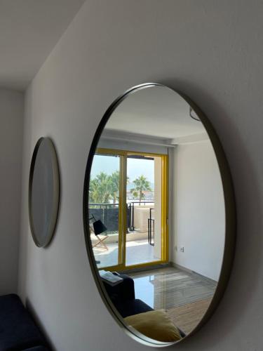 a round mirror on a wall with a window at Vistas al mar, en el club náutico de Sant Carles de la Rápita, 3 dormitorios in Sant Carles de la Ràpita