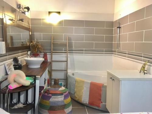La salle de bains est pourvue d'une baignoire, d'un lavabo et d'un comptoir. dans l'établissement Appart Central à Sète avec balcon, à Sète