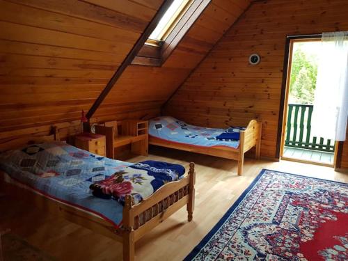 a bedroom with two beds in a log cabin at Domek w otulinie Wigierskiego Parku Narodowego in Aleksandrowsk