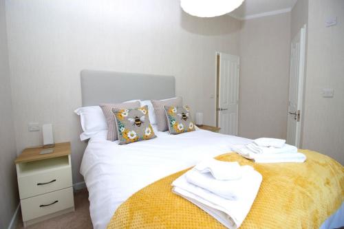 a bedroom with a white bed with towels on it at Hollicarrs - Bumblebee Lodge in York