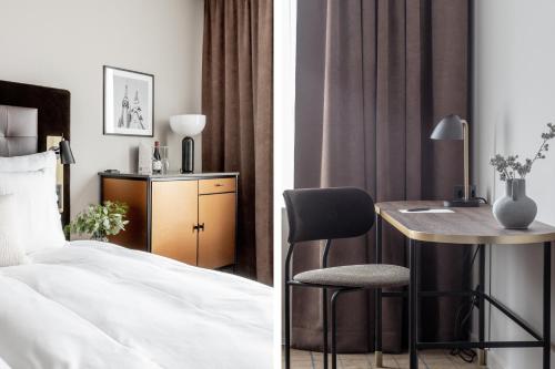 a bedroom with a bed and a table and a chair at Clarion Hotel Sundsvall in Sundsvall