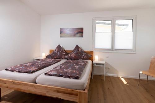 um quarto com 2 camas e uma janela em Ferienhaus Stöcklin Nähe Europapark Rust em Weisweil