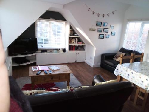 a living room with a couch and a table at Leylands - Perfect location near town and beach in Cromer