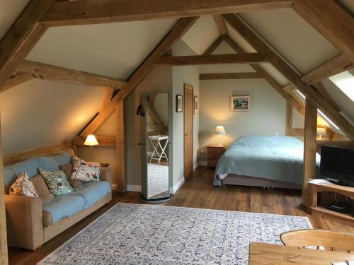 um quarto com uma cama e um sofá num quarto em Impstone House B & B em Bower Chalke