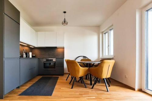 a kitchen with a table and yellow chairs at Lake View Suite in Mörbisch am See