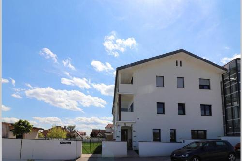 a white building with a car parked next to it at Lake View Suite in Mörbisch am See