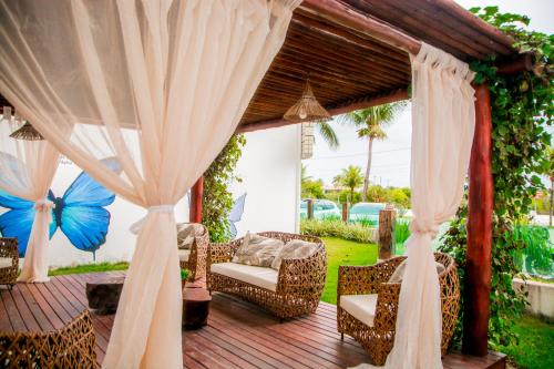 a wooden deck with a gazebo with curtains at Cahy Praia Hotel in Prado