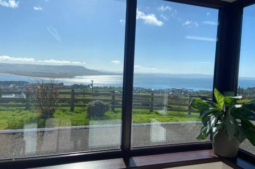 a room with a window with a view of the ocean at Hannon’s Cottage - A piece of paradise in Greencastle