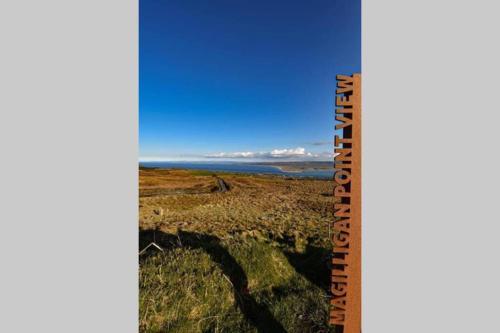 a ruler of a field with the ocean in the background at Hannon’s Cottage - A piece of paradise in Greencastle