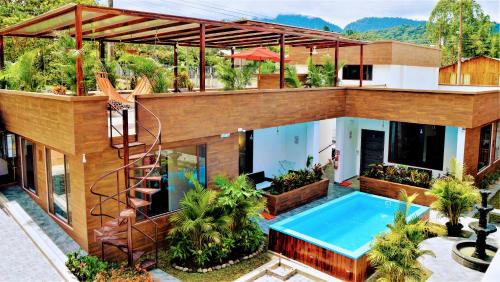 a house with a swimming pool and a spiral staircase at Toucan Platinum Suites Aparthotel in Mindo