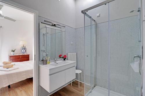 a bathroom with a sink and a glass shower at Vilamoura Golf Villa 1 With Pool by Homing in Vilamoura