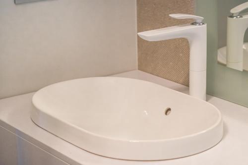 a bathroom with a white sink and a faucet at Pensiunea Iristar in Fălticeni