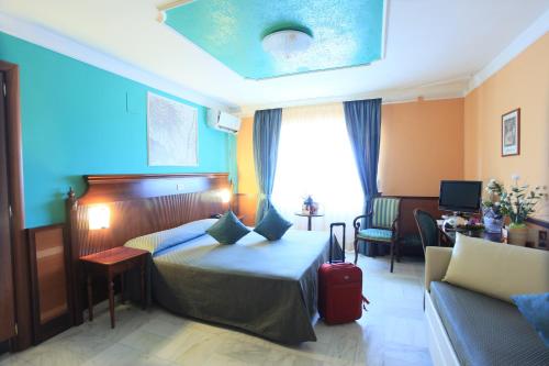 ルチェーラにあるBalconata 2.0 Banqueting & Accommodationsのベッドとソファ付きのホテルルーム