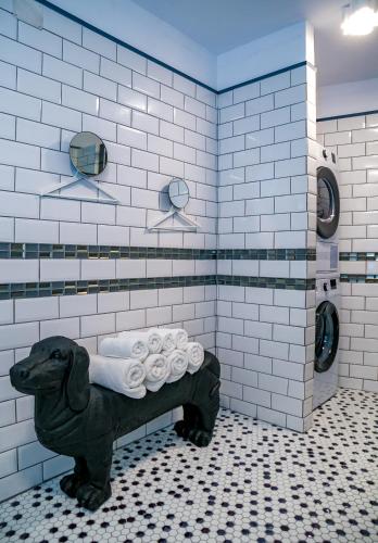 a bathroom with a dog statue in the shower at Villa Casafina Serviced Apartments in Mangalia