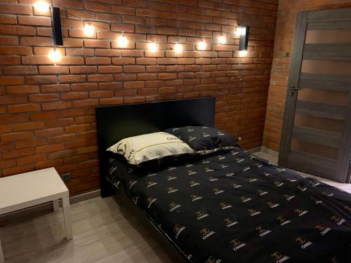 - une chambre avec un lit éclairé sur un mur en briques dans l'établissement Apartament na 1 Maja -4-, à Skierniewice