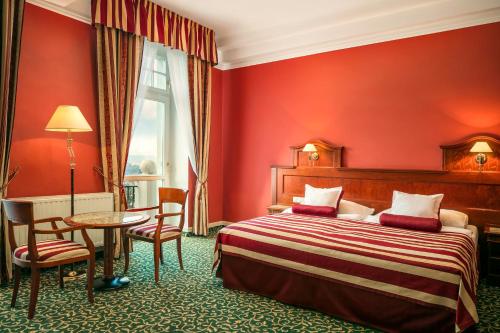 une chambre d'hôtel avec un lit, une table et des chaises dans l'établissement Spa Hotel Imperial, à Karlovy Vary