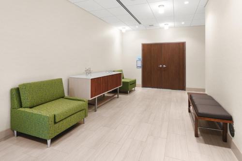 a waiting room with a green chair and a door at Holiday Inn Express & Suites - Suisun City by IHG in Suisun City