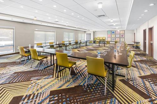 a conference room with long tables and yellow chairs at Holiday Inn Express & Suites - Suisun City by IHG in Suisun City