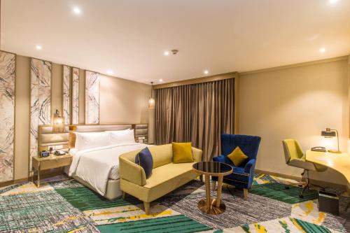 a hotel room with a bed and chairs and a desk at Holiday Inn Chandigarh Zirakpur by IHG in Chandīgarh