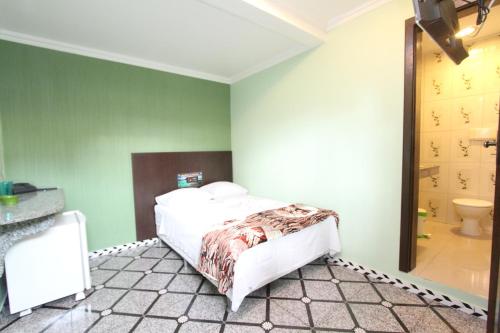 a bedroom with a bed and a bathroom with a toilet at Hotel Lagoa in Manaus